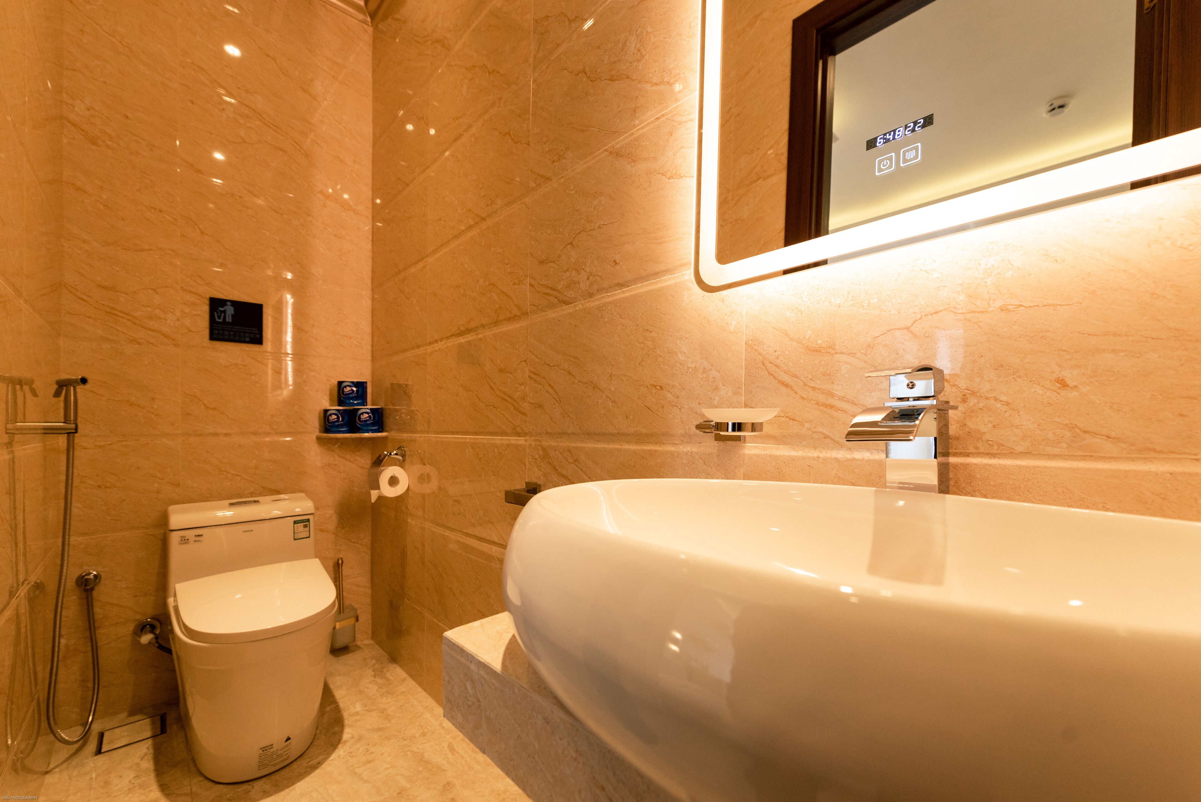 A modern bathroom with a large bathtub, a toilet, and a shower area.