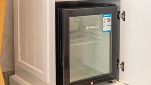 Una cocina compacta equipada con un refrigerador, un microondas y un horno pequeño.