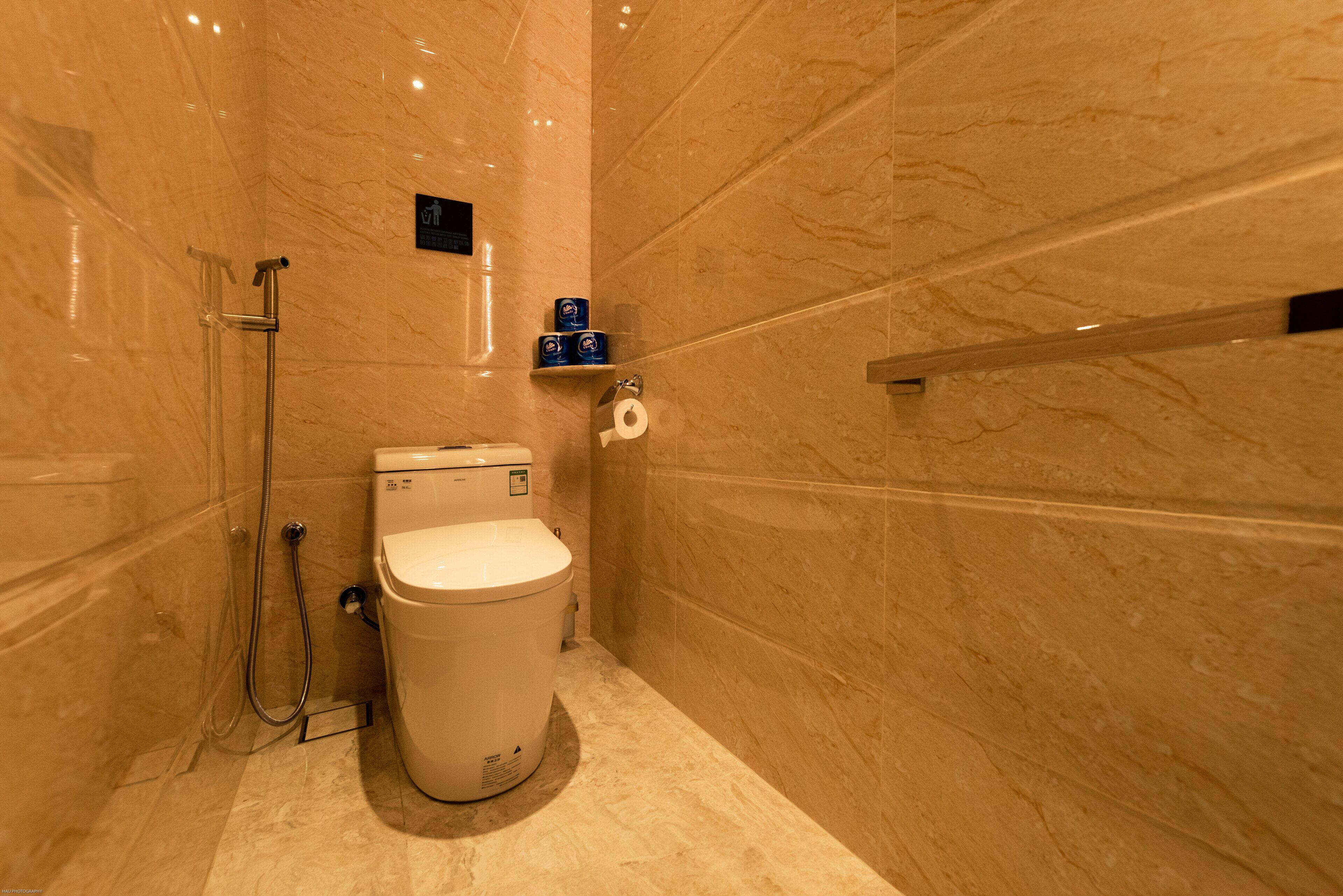 Un baño con inodoro, ducha y secamanos.