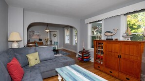 A living room with a gray sofa, a wooden cabinet, and a blue and white table.