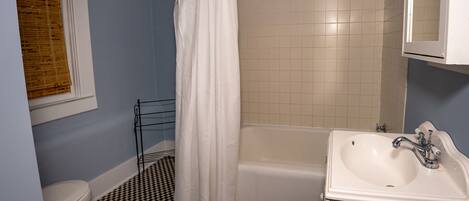 A bathroom with a bathtub, a toilet, and a sink.