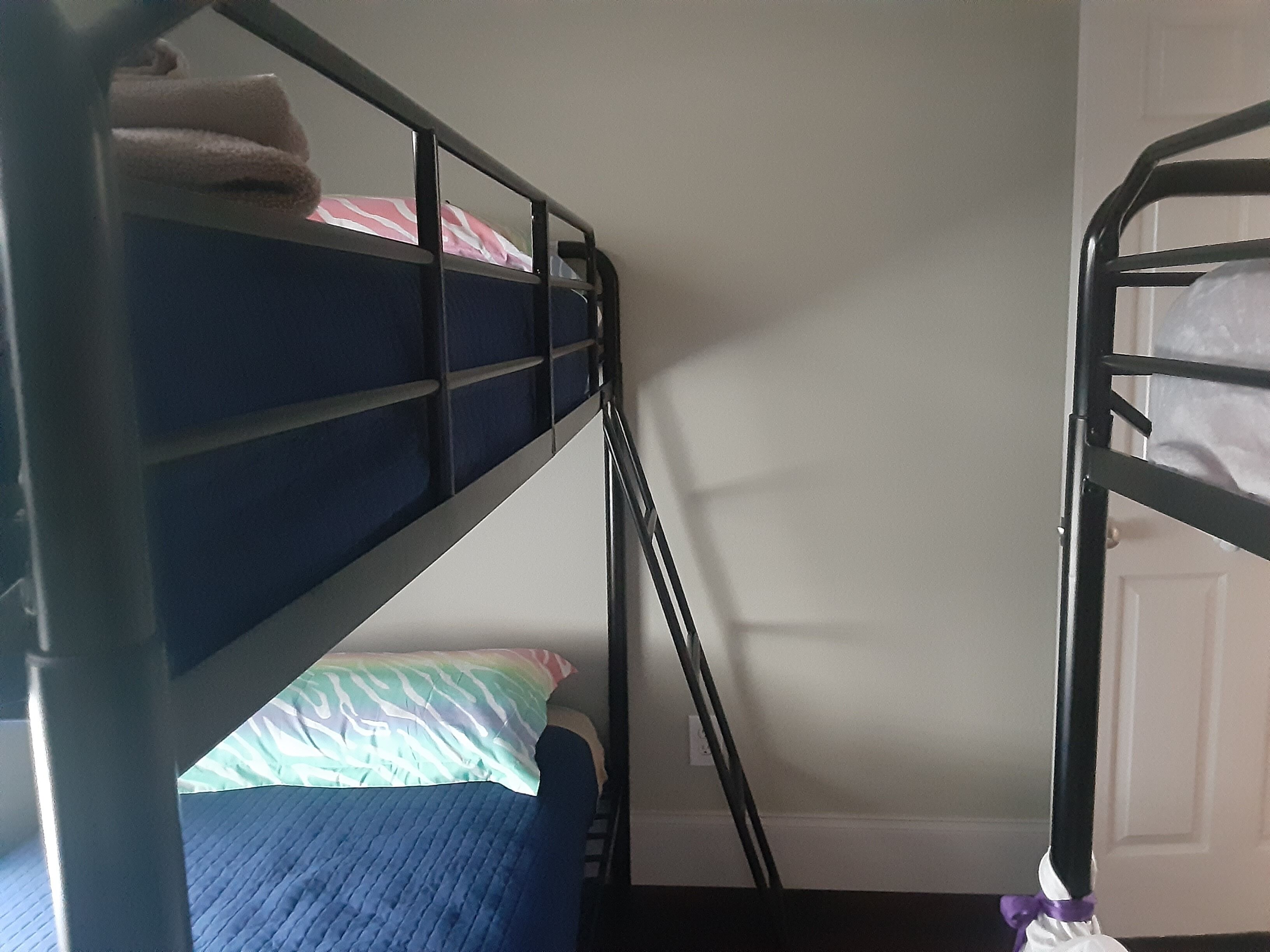 Una camera con un letto a castello, una porta e una finestra.