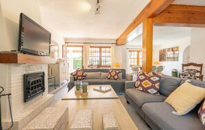 Smart-tv, eldstad och ett bordtennisbord