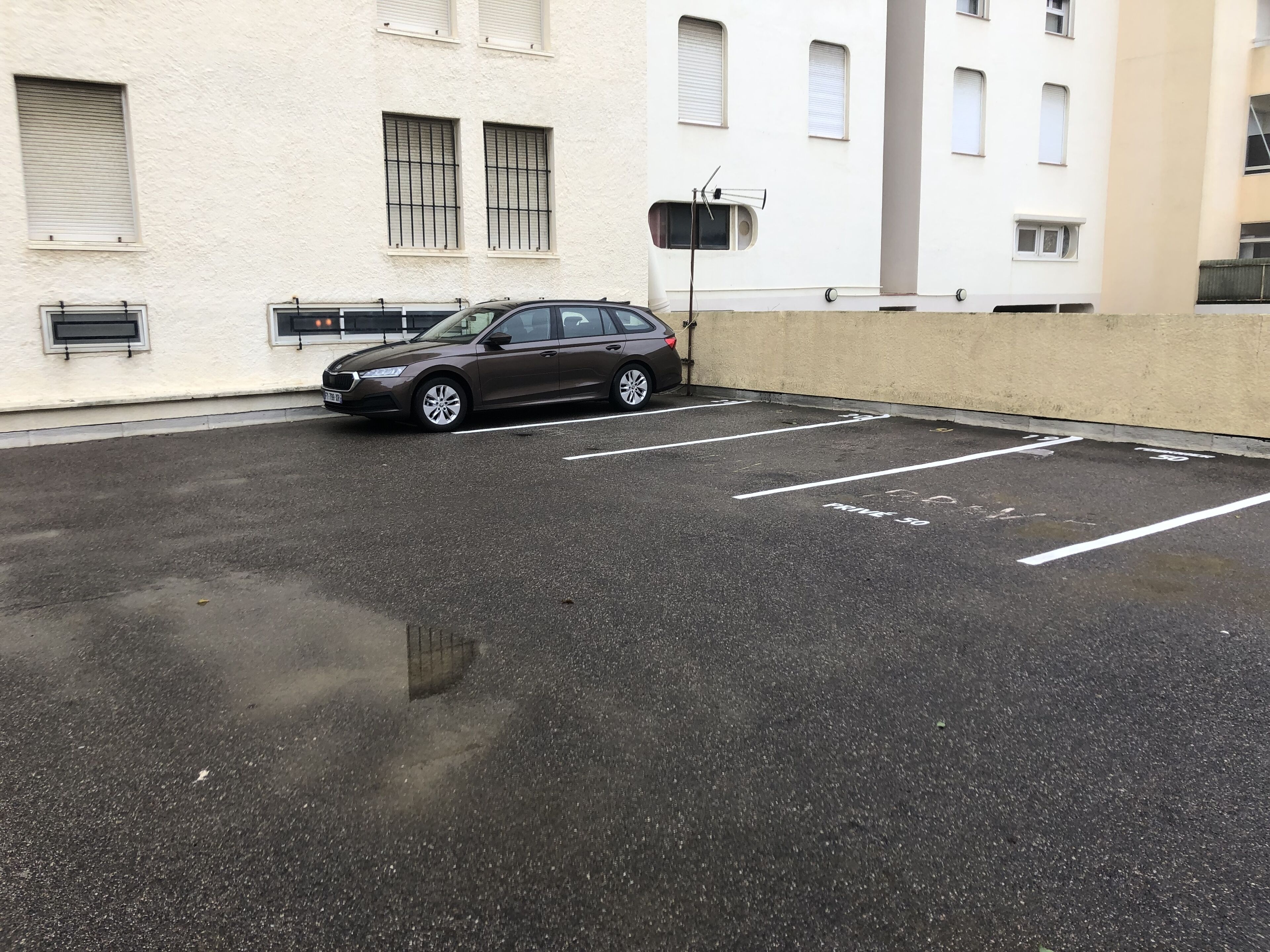 Un estacionamiento con un coche aparcado en un espacio reservado.