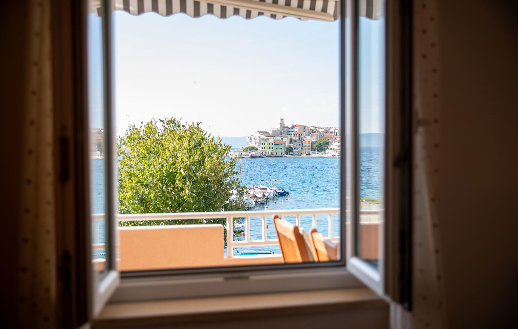A balcony with a view of a coastal town and the sea.