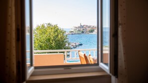 Een balkon met uitzicht op een kustplaatsje en de zee.