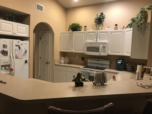 Fully equipped kitchen with refrigerator, microwave, oven, and coffee maker.