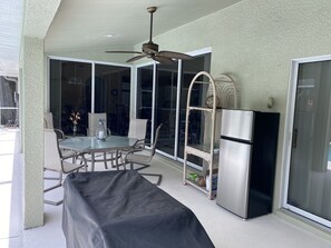 Enjoy dining al fresco in this covered outdoor space with a glass-enclosed area and sliding door leading to the interior.