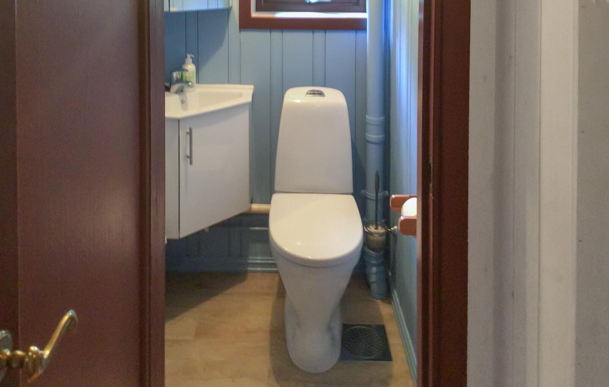 Ein kleines Badezimmer mit Toilette, Waschbecken und einem Schrank.