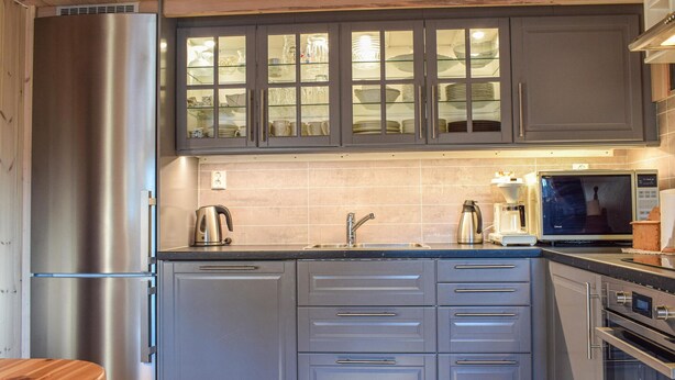 A modern kitchen with grey cabinets, a stainless steel refrigerator, a built-in microwave, and a coffee maker. - Awesome home in Sjusjøen with WiFi (Sjusjøen)