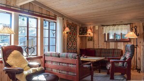 A cozy cabin interior with wooden walls, a bench, a chair, and a table. - Awesome home in Sjusjøen with WiFi (Sjusjøen)