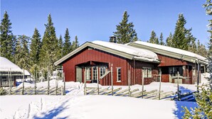 A red wooden cabin with a snow-covered roof, surrounded by snow and trees. - Awesome home in Sjusjøen with WiFi (Sjusjøen)