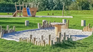 Une aire de jeux avec un toboggan et des structures d’escalade.