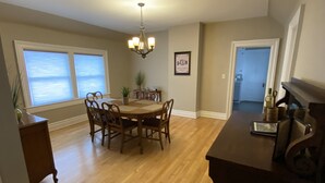 A dining area with a wooden table and chairs, a chandelier, and a potted plant. - Close to Downtown & UWEC (Eau Claire)