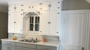 A kitchen with white cabinets, a double sink, and a window above the sink. - Close to Downtown & UWEC (Eau Claire)