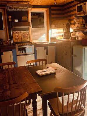 A kitchen with a stove, refrigerator, and wooden cabinets. - Vintage Home 55 (Eisenach)