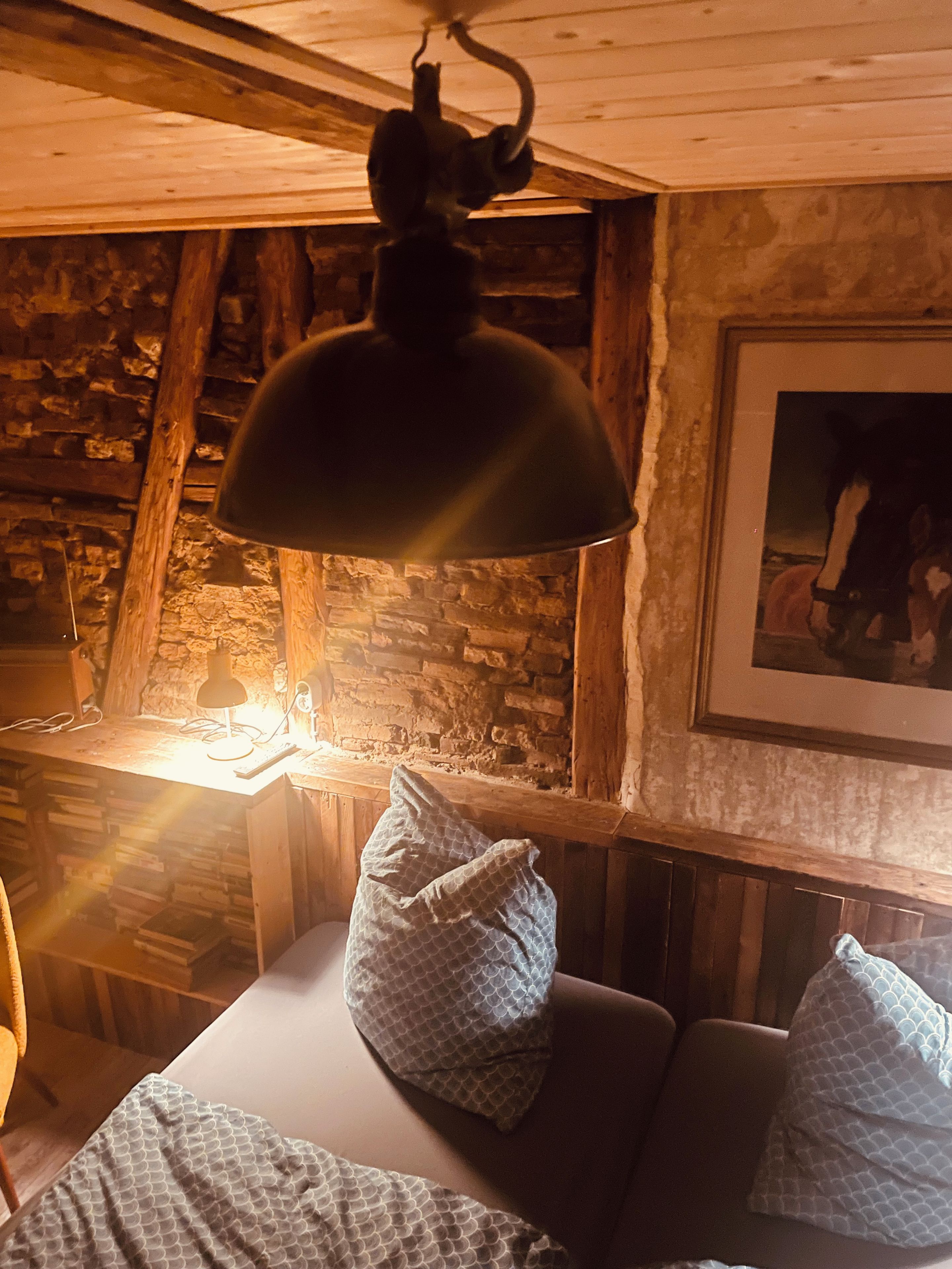 Une pièce confortable avec un lit, des oreillers, une table et une lampe.