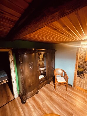 A room with a wooden cabinet, a chair, and a bed. - Vintage Home 55 (Eisenach)