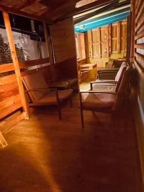 A cozy wooden interior with a seating area, a table, and a view through a window.
