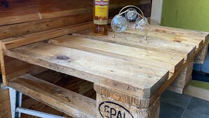 A wooden table with a bottle of Wilthener Goldkrone and two glasses. - Vintage Home 55 (Eisenach)