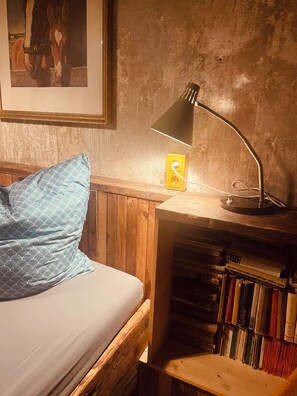 A room with a bed, a lamp, a bookshelf, and a framed picture on the wall. - Vintage Home 55 (Eisenach)