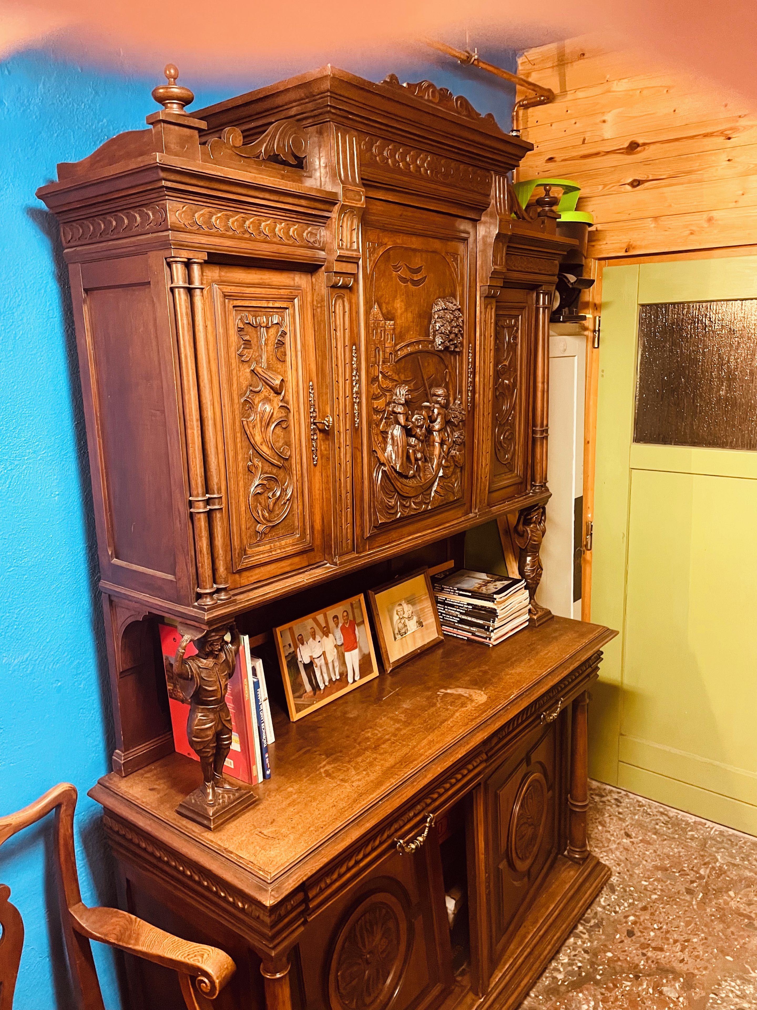 Un mueble de madera con intrincados grabados y una puerta con panel de vidrio.