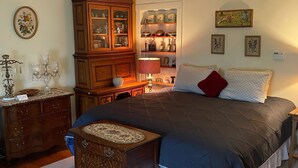 A bedroom with a large bed, a wooden cabinet, a chandelier, and a rug. - Cooperstown Dreams Park Baseball Rental All Star Village Catskills Oneonta (Mount Vision)