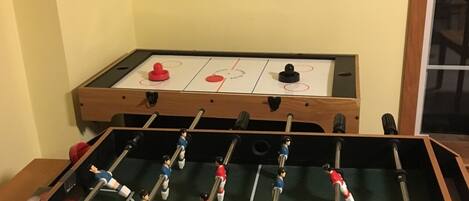 Una mesa de futbolín con un dardo colgado encima.