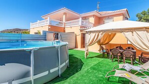 A swimming pool, a covered outdoor seating area, and a house with a balcony. - Villa Natalia (Benajarafe)