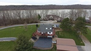 A large house with a spacious front yard, a driveway, and a garage. - Lake house with boat ramp access across the street & tons of boat parking space. (Monticello)