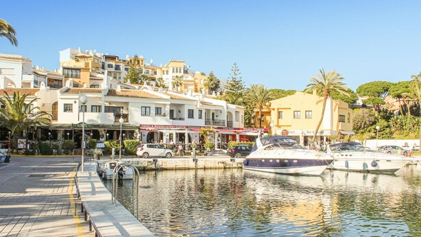 A marina with boats docked, a waterfront promenade, and buildings with restaurants. - 2 bedroom awesome apartment in Marbella (Marbella)