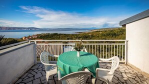 A balcony with a table and chairs, overlooking a scenic view of a body of water and distant hills. - Awesome apartment in Klenovica with WiFi (Klenovica)