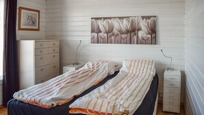 Quarto com duas camas, cômoda, mesa de cabeceira, abajur e um quadro na parede.