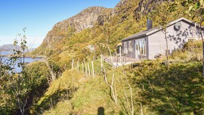 Uma casa com vista para um lago e montanhas.
