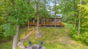 A cabin with a deck, surrounded by trees. - Private, family friendly lake home w/sandy beach in Crosslake on Pine Lake (Crosslake)