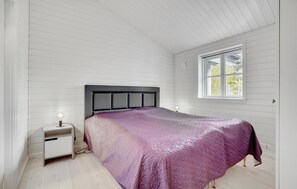 Ein Schlafzimmer mit einem Bett, einem Nachttisch und einem Fenster.