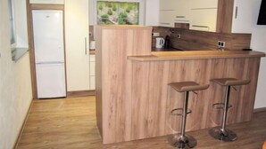 A modern kitchen with a wooden island and bar stools. - Nebahovy u Prachatic by Interhome (Prachatice)