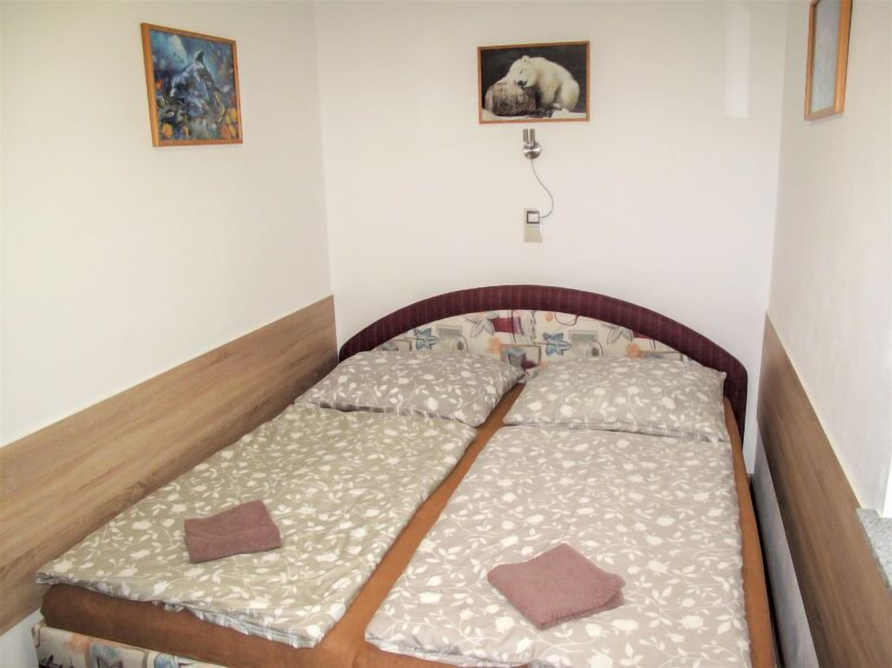 Un letto matrimoniale con biancheria da letto floreale, una testiera in legno e due cuscini.