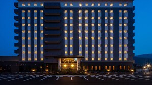 A multi-story hotel with a symmetrical facade, evenly spaced windows, and a central entrance with a canopy. - Hotel Route Inn Tsuyama Ekimae (Tsuyama)