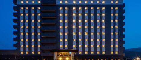 A multi-story hotel with a symmetrical facade, evenly spaced windows, and a central entrance with a canopy.