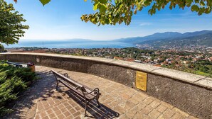 A stone bench overlooking a coastal town with a clear view of the sea and mountains in the distance. - Nice apartment in Kastav (Kastav)