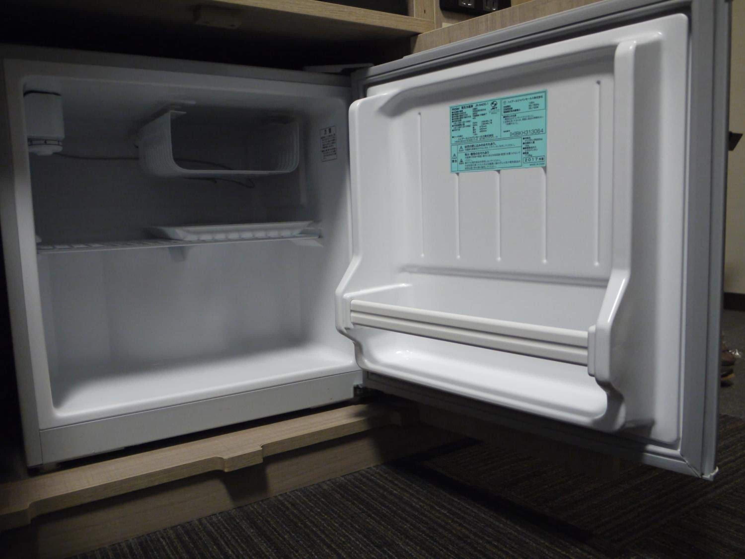 An open refrigerator with a control panel and a warning label.