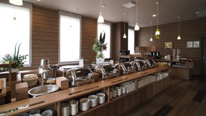 Una barra de desayuno moderna con varias estaciones de servicio, una máquina de café y una zona de estar con detalles de madera.