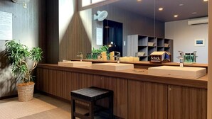 Un baño moderno con paneles de madera, dos lavamanos, un espejo grande y un taburete pequeño.