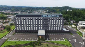 Un hotel moderno con techo plano, varios pisos y un amplio estacionamiento.