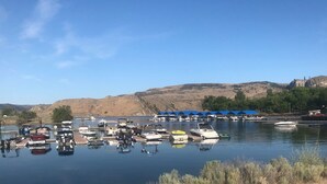 A marina with boats docked, a clear sky, and hills in the background. - Fishing Bungalow at Keller Ferry (Wilbur)