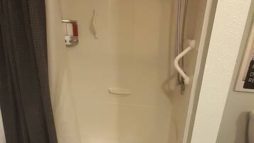 Una ducha con puerta de cristal, un perchero y un panel de control.