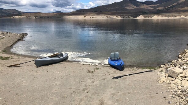 A calm lake with kayaks and a paddle on the shore. - Fishing Bungalow at Keller Ferry (Wilbur)