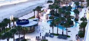 Un resort con piscina, palmeras y una playa.