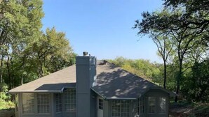 A house with a chimney, a covered porch, and a fenced yard. - Austin Home (Austin)
